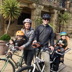 Xtracycle Electric cargo bike with two orange Yepp seats on back and brown walnut wood front coff...